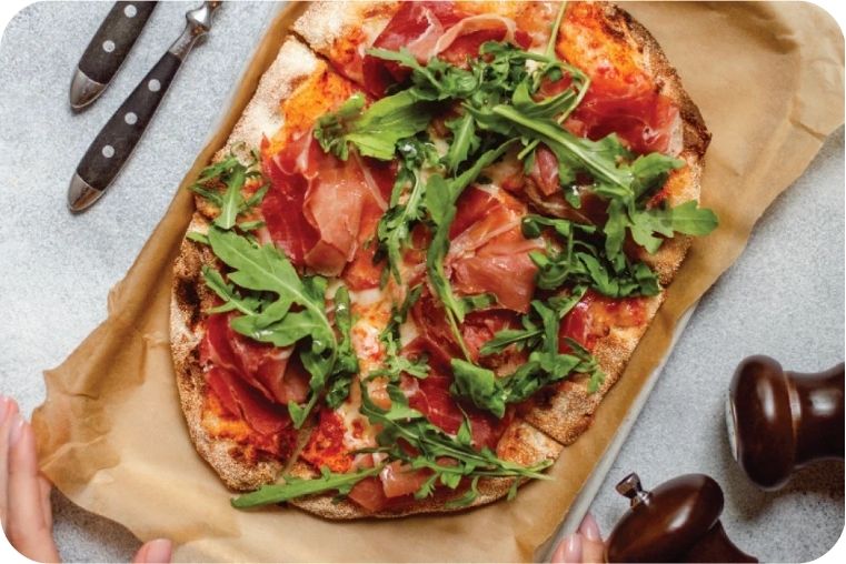 Wholegrain Pizza with rocket tomato and prosciutto